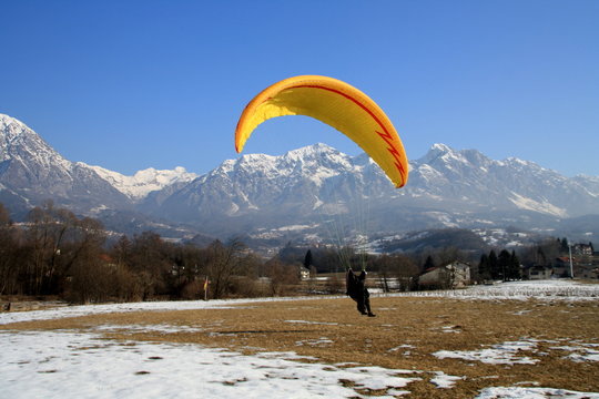Paragliding on landing in the snow at Dolada mountain
