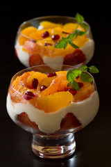 Dessert of orange, pomegranate seeds,strawberry and cream