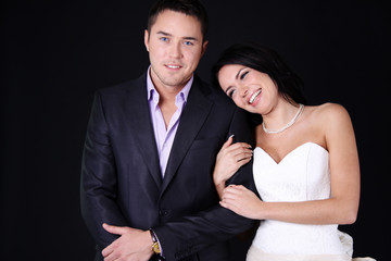 Bride and groom posing on dark studio background