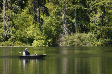Fototapeta na wymiar Man in a boat fishing on a lake.