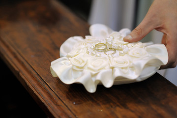 Two wedding rings on a pillow