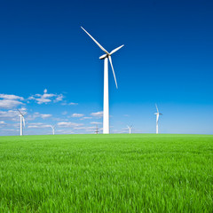 Wind power station - wind turbine against the blue sky