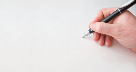 Human hand over white paper with pen