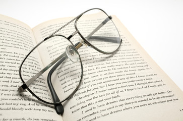 closeup of opened book and glasses.