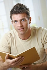 Man with book looking at camera