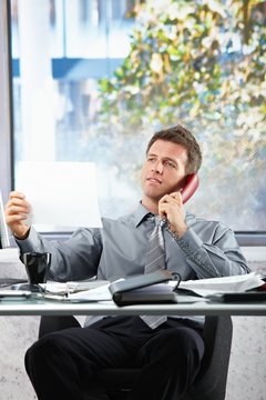 Businessman  on call looking at paper