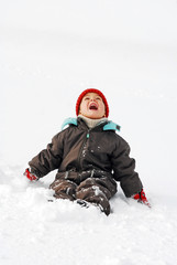 Fototapeta na wymiar Junge sitzt im Schnee