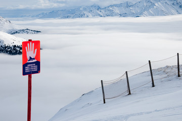 Lawinenwarnschild über Talnebel