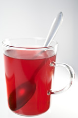 Glas mit Früchtetee und Löffel