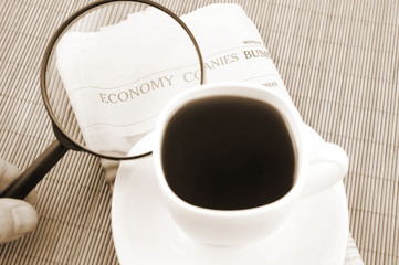 Magnifying glass with coffee cup and newspaper