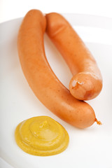 ein Paar Wiener Würstchen auf einem weißen Teller