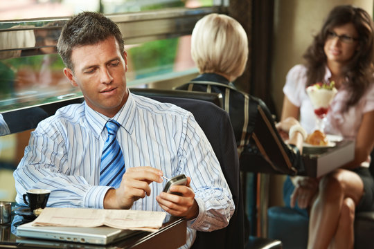 Businessman using mobile in cafe