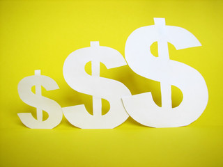 us dollar sign cut from paper on golden background