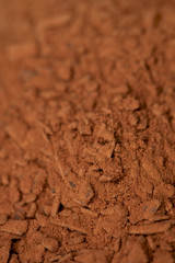 cocoa powder with small pieces of chocolate on background with s