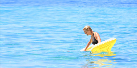 woman in bikini on a mattress in the sea