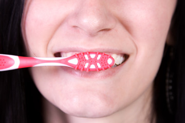 Fototapeta premium Close up of a beautiful woman brushing her teeth