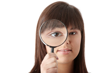 Businesswoman looking into a magniying glass