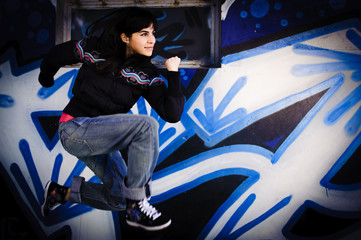 Mädchen springt vor Graffity Wand