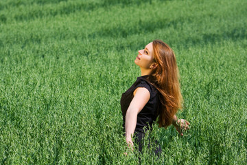 Happy young woman relaxing in a field.