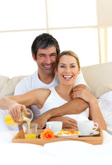 Obraz na płótnie Canvas Romantic couple having breakfast lying in the bed