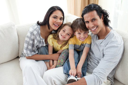 Joyful family sitting on sofa