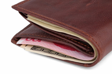 Brown leather wallet with dollar and yuan banknotes over white