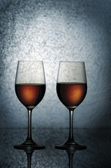 Two glasses of white wine on a dark blue background