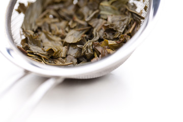 Ausschnitt von Teesieb mit grünem Tee