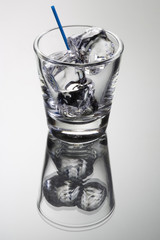 Empty cocktail tumbler with ice cubes