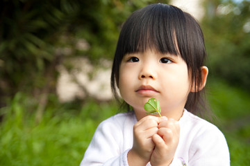 Young child holding a plant in her hand