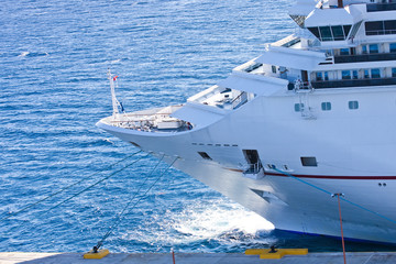 Fototapeta na wymiar Bow of White Cruise Ship Anchored on Blue Water