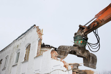Abriss eines alten Geb&auml;udes durch einen Bagger