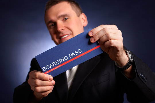 Business man holding a boarding pass