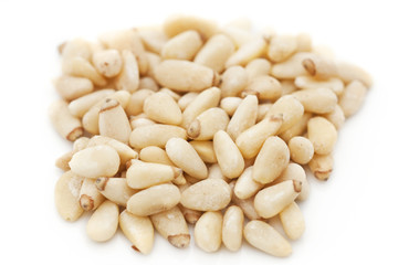 Pine nuts on light background with shadow and reflection.