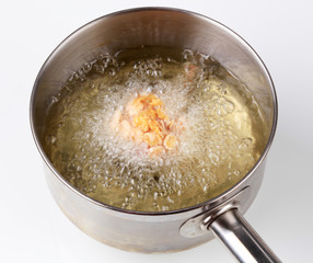 Corn flake chicken drumstick being deep fried