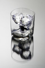 Empty glass tumbler with ice cubes
