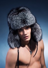 Portrait of handsome young man wearing fluffy hat