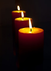 Burning red candles on the black
