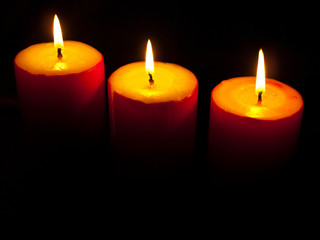 Burning red candles on the black