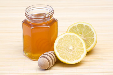 jar of honey, lemon and wooden drizzler