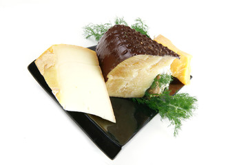 aged cheeses on black plate