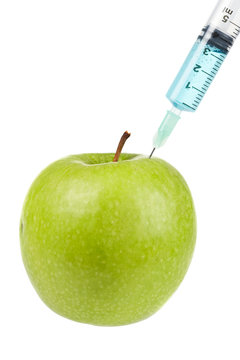 Green apple with syringe inserted