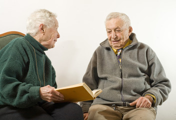 couple de personnes agées lisant un livre