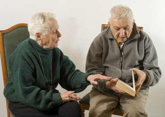 couple de personnes agées lisant un livre