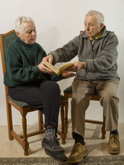 couple de personnes ag&eacute;es lisant un livre