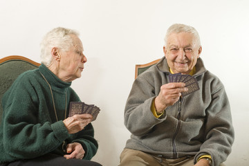 couple de personnes agées jouent aux cartes