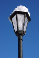 lamp in the snow against the blue sky