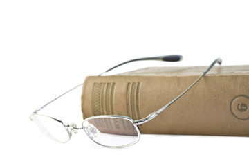 Book and glasses isolated on white background