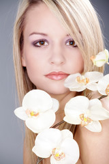 Obraz na płótnie Canvas Junge blonde Frau Gesicht mit Orchidee Porträt
