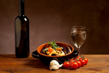 ciotola con spagehtti ai  gamberi e bottiglia di vino